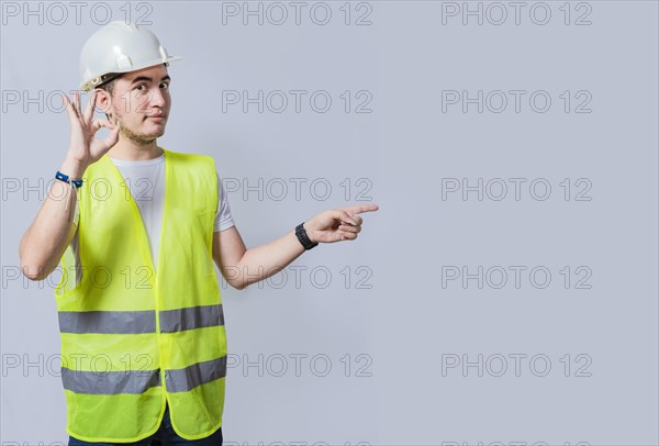 Handsome engineer recommending a product on white background