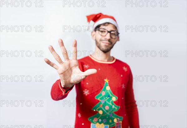 Man in christmas hat counting number five with fingers. Man in christmas costume counting number five with fingers. Concept of man in christmas costume counting number five isolated