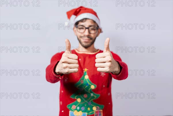 Young man in christmas hat giving thumbs up with both hands. People in santa hat ok gesture with fingers isolated. Christmas man concept with thumbs up in ok gesture