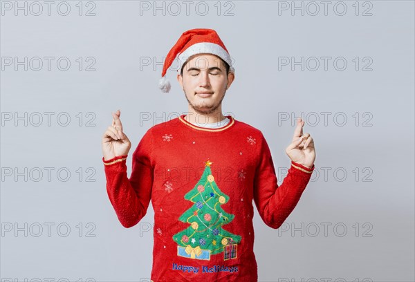 Hopeful man in christmas clothes making a wish