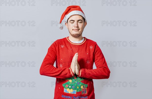 Guy with hands together praying in christmas isolated