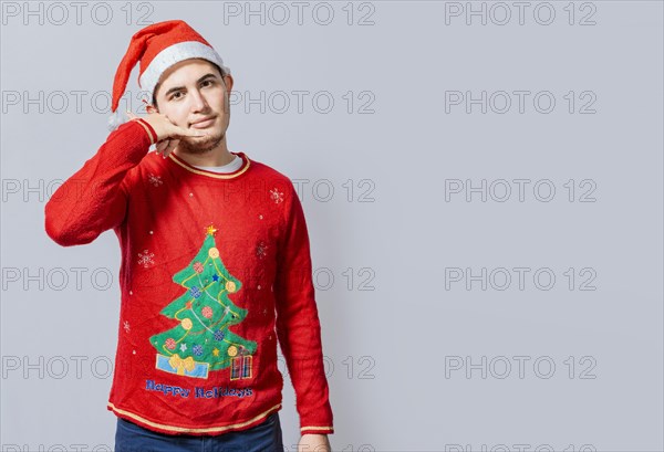 Man in christmas clothes imitating a phone conversation