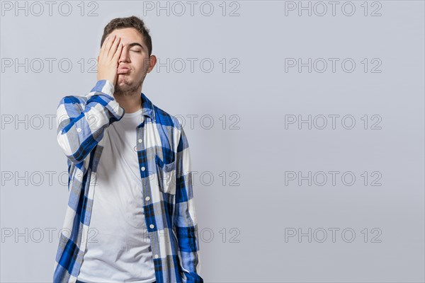 Exhausted person putting the palm of his hand on his face. Tired and exhausted man covering his face with the palm of his hand isolated