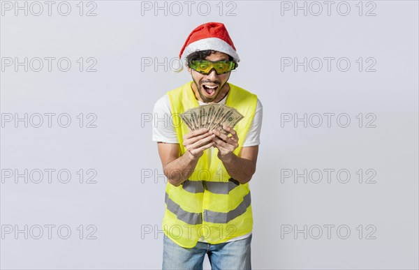 Builder engineer in christmas hat with happy expression holding dollars isolated. Concept of engineer with money in holiday season