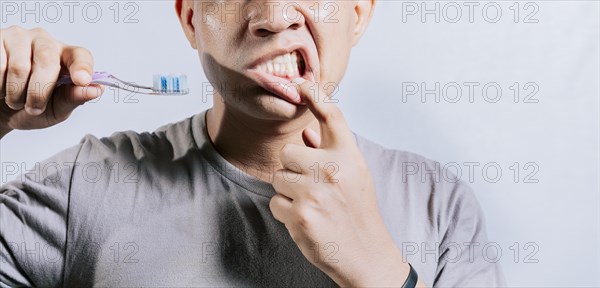 Person with gingivitis holding toothbrush. People holding toothbrush with gum pain. Man holding toothbrush with gum pain
