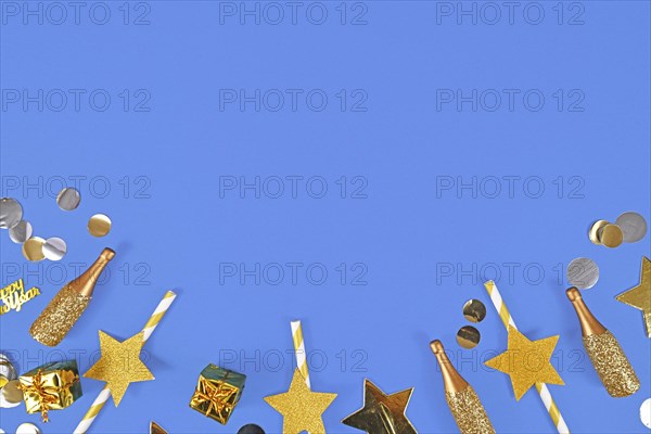 New year flat lay with golden party items on blue background with copy space