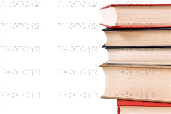 Stack of old hardcover books on side of white background with copy space