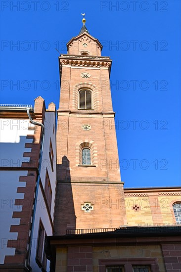Clock tower of catholic St. Laurentius church in Weinheim city in Germany in front of blue sky