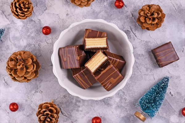 German layered winter cake pralines called Baumkuchen glazed with chocolate in bowl