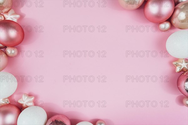 Top view flat lay with various pink and white Christmas tree bauble and star ornament on pastel pink background