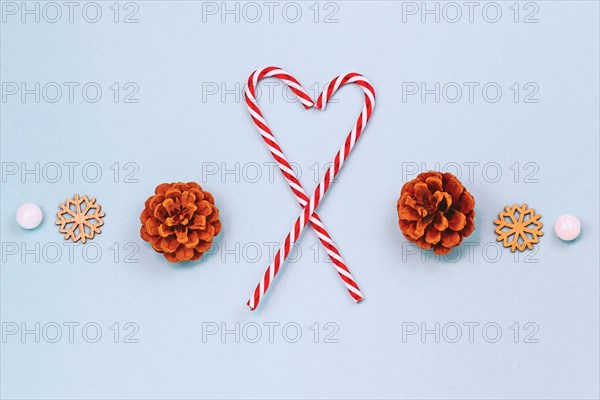 Seasonal winter flat lay with two red and white striped candy canes forming shape of a heart