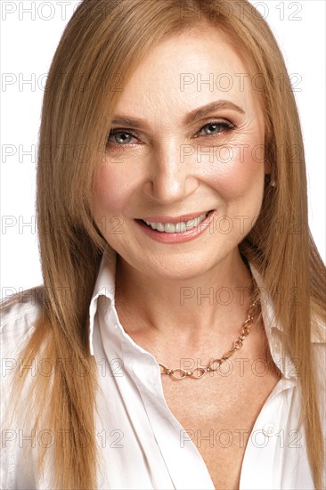 Portrait of a beautiful elderly woman in a white shirt with classic makeup and blond hair