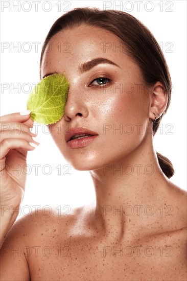 Beautiful girl with nude classic makeup and bright autumn leaves. Beauty face. Picture taken in the studio on a white background