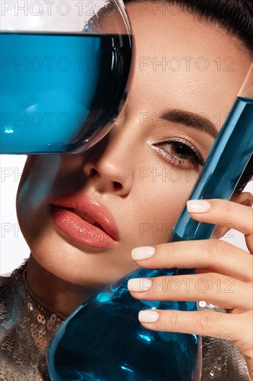 Beautiful woman with laboratory containers with liquid