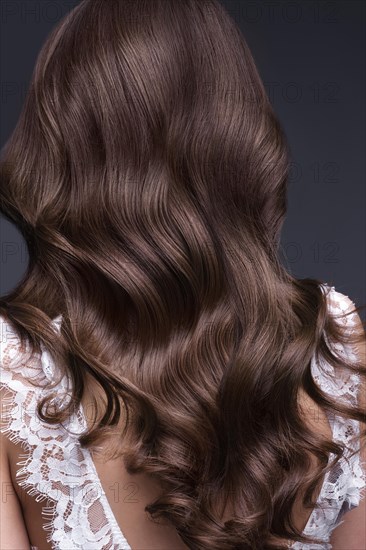 A closeup view of a bunch of shiny curls brown hair