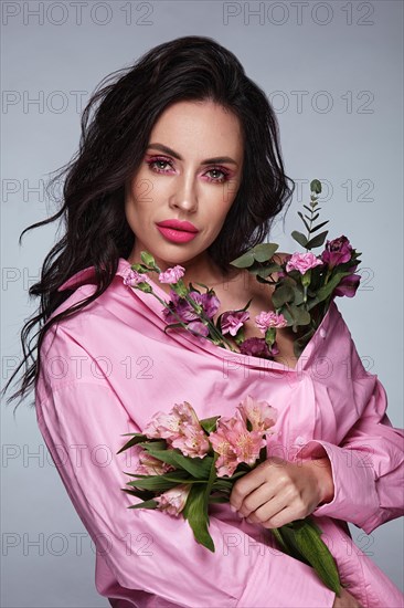 Beautiful brunette girl with a gentle pink romantic make-up