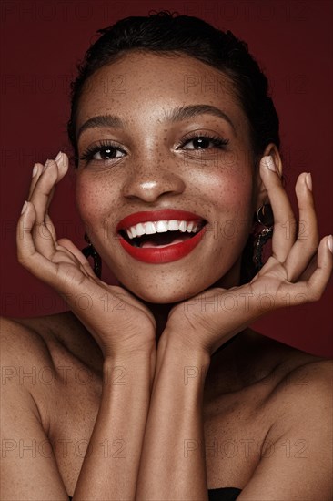 Beautiful black woman with a smile and red lips and freckles. Beauty face. Photo taken in the studio