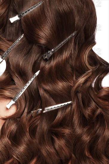 A closeup view of a bunch of shiny curls brown hair