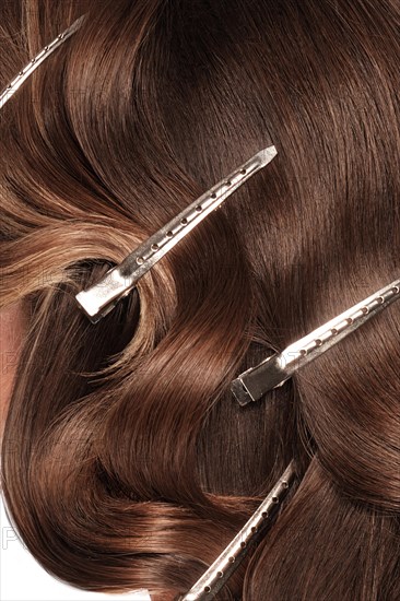 A closeup view of a bunch of shiny curls brown hair