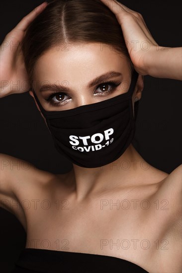 Portrait of a beautiful woman in a black mask stop covid and classic makeup. Mask mode during the covid pandemic