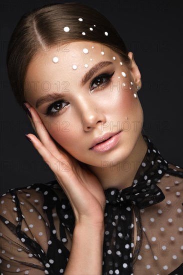 Portrait of a beautiful woman in a black dress with pearls and classic makeup. Beauty face