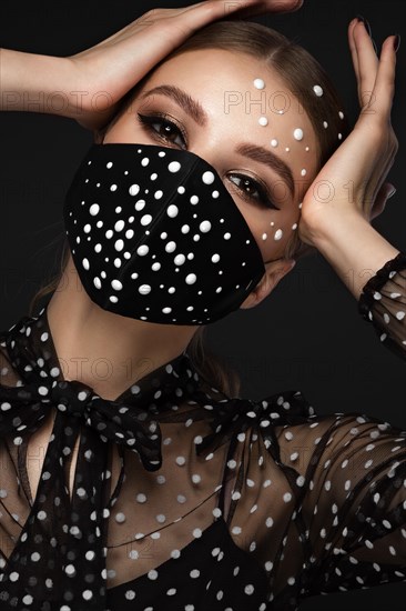 Portrait of a beautiful woman in a black dress with pearls and classic makeup. Beauty face