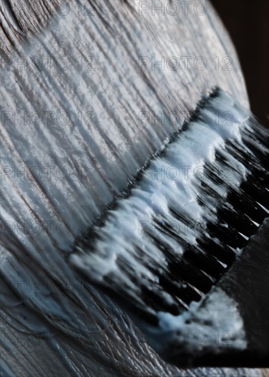 A young woman in a hairdressing salon dyes her hair blond. Hair coloring process