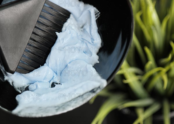 The hairdresser kneads the hair dye in the salon. Hair coloring process