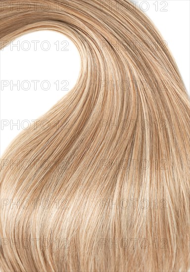 A strand of blond hair on a white background. Close-up
