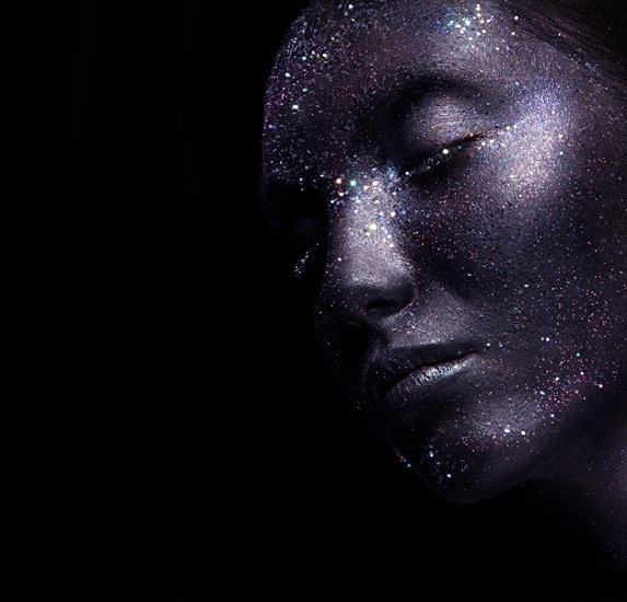 Portrait of beautiful woman with art glitter makeup on her face