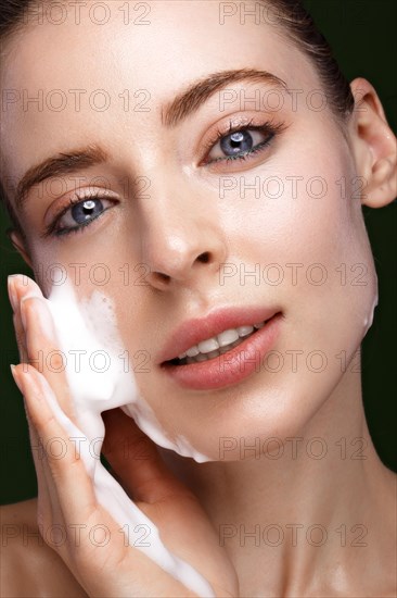 Beautiful young girl with cream on the skin. Beauty face. Picture taken in the studio