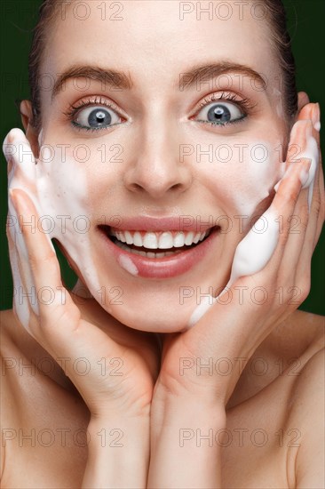 Beautiful young girl with cream on the skin. Beauty face. Picture taken in the studio