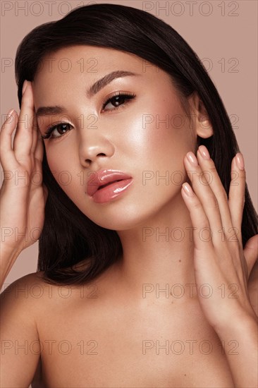 Beautiful delicate woman of oriental type with nude makeup and perfect skin. Beauty face. Spa salon