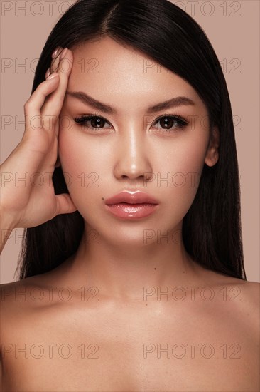 Beautiful delicate woman of oriental type with nude makeup and perfect skin. Beauty face. Spa salon