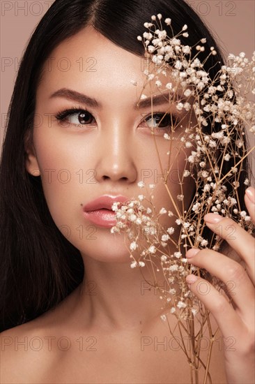 Beautiful delicate woman of oriental type with nude makeup and perfect skin. Beauty face. Spa salon