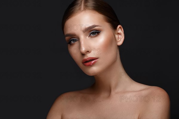 Beautiful girl with sexy lips and classic makeup with cosmetic blue eyeliner. Beauty face. Photo taken in the studio