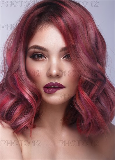 Beautiful girl with multi-colored hair and classic make-up and hairstyle. Beauty face. Photo taken in the studio