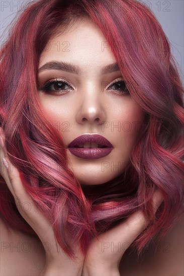 Beautiful girl with multi-colored hair and classic make-up and hairstyle. Beauty face. Photo taken in the studio