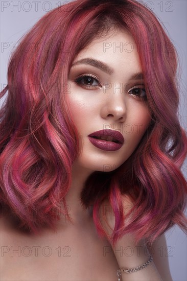 Beautiful girl with multi-colored hair and classic make-up and hairstyle. Beauty face. Photo taken in the studio