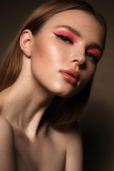 Portrait of a beautiful woman with pink creative make up. Beauty face. Photos shot in studio