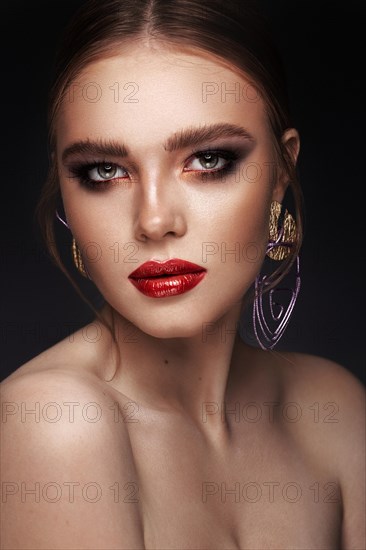 Beautiful girl with bright fashionable make-up and unusual purple accessories. Beauty face. Photo taken in the studio