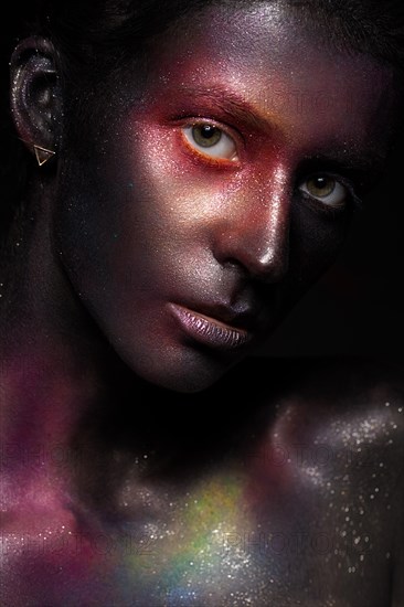 Beautiful girl with art space makeup on her face and body. Glitter Face. Photo taken in the studio