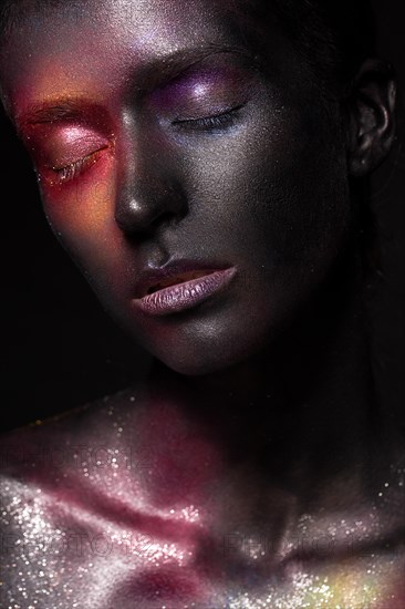 Beautiful girl with art space makeup on her face and body. Glitter Face. Photo taken in the studio