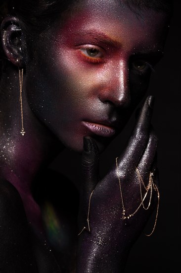 Beautiful girl with art space makeup on her face and body. Glitter Face. Photo taken in the studio