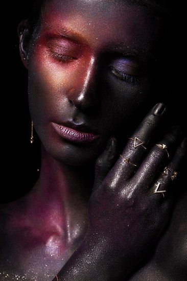 Beautiful girl with art space makeup on her face and body. Glitter Face. Photo taken in the studio