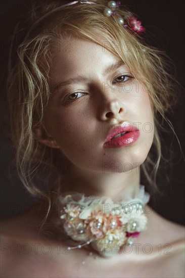 Beautiful blond fashion girl with flowers on the neck and in her hair