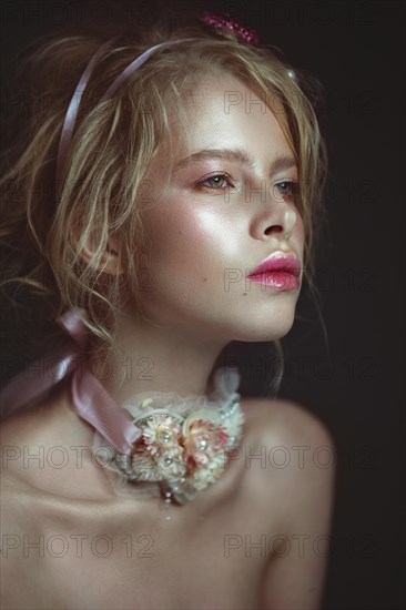 Beautiful blond fashion girl with flowers on the neck and in her hair