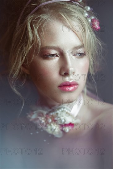 Beautiful blond fashion girl with flowers on the neck and in her hair