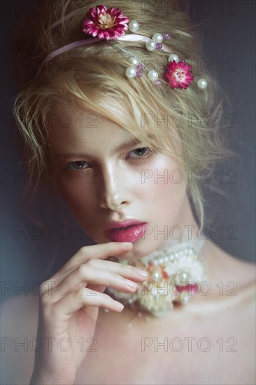 Beautiful blond fashion girl with flowers on the neck and in her hair