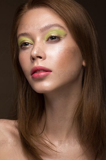 Beautiful red-hair girl with creative green makeup. Beauty face. Photos shot in studio